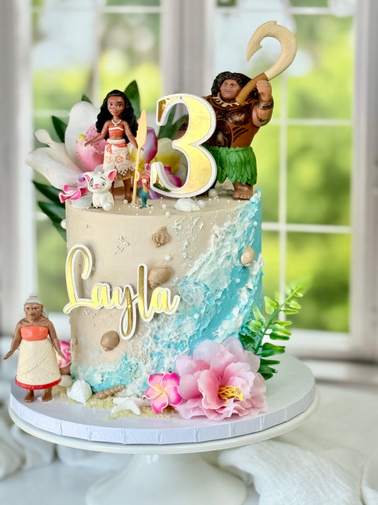 Tropical island princess cake with ocean buttercream waves, sandy textures, and bright florals – perfect for themed birthday parties.