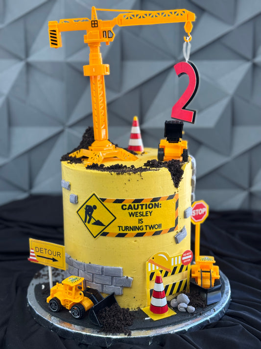 Construction birthday cake with buttercream dirt textures, caution stripes, and builder theme details – perfect for children’s parties.